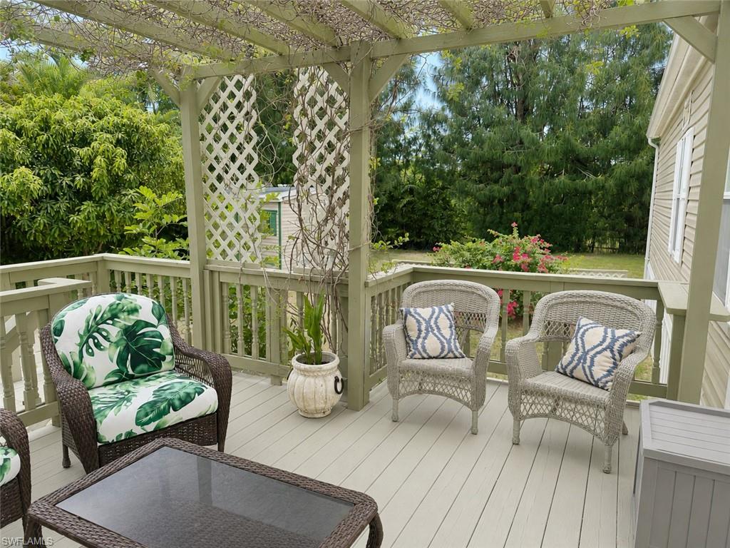 Spacious outdoor deck featuring a wooden pergola, lattice accents, and perimeter railing