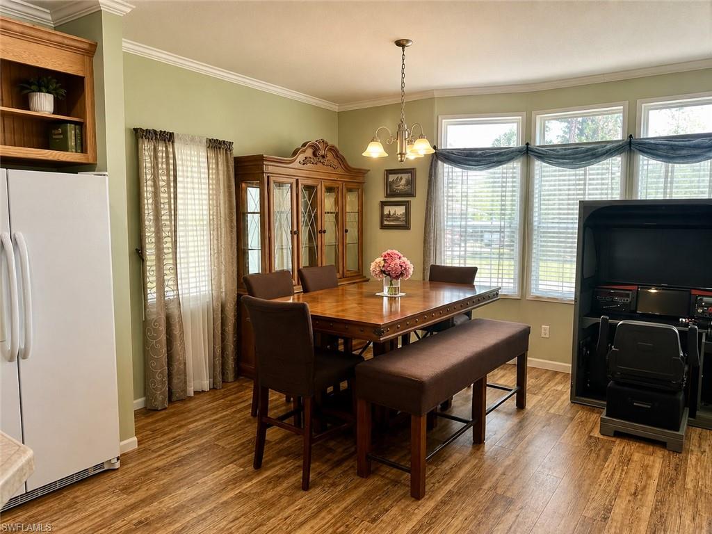 Dining area featuring wood-finish flooring and crown molding