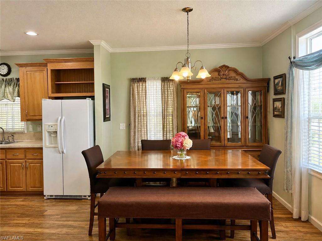 Dining area featuring wood-finish flooring and crown molding