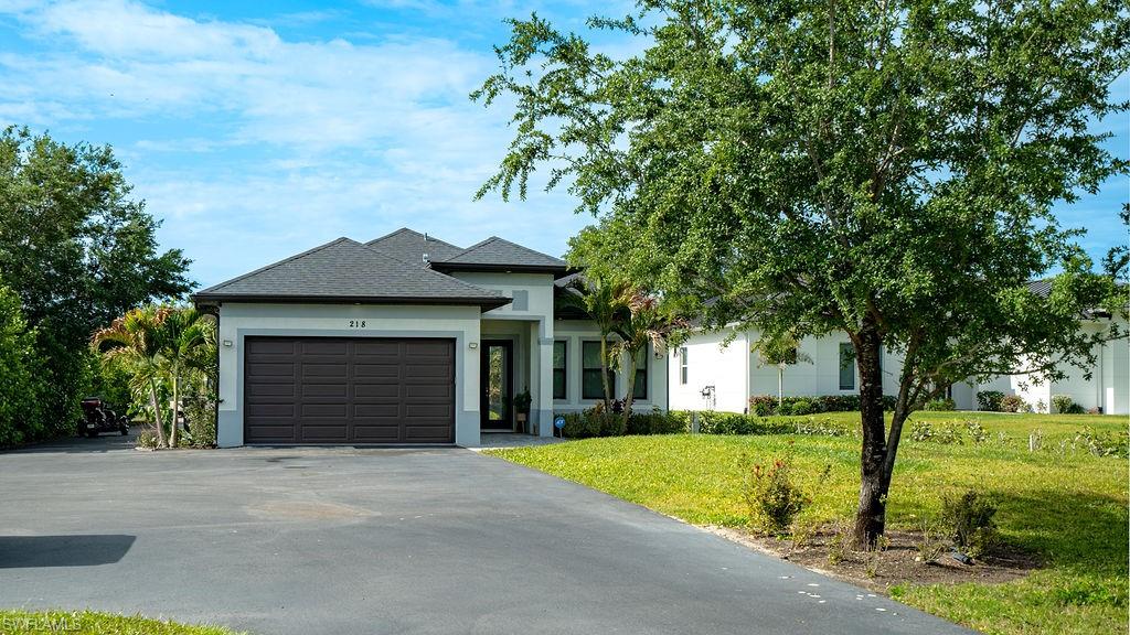 Contemporary single-story residence featuring a dark asphalt shingle roof and light gray stucco exterior