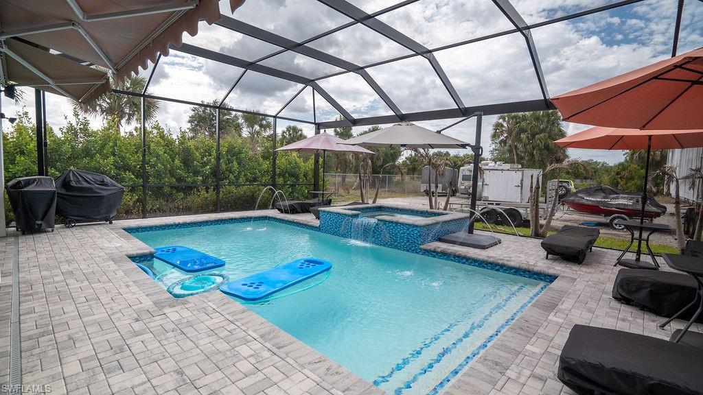 Screened lanai featuring a swimming pool and integrated spa