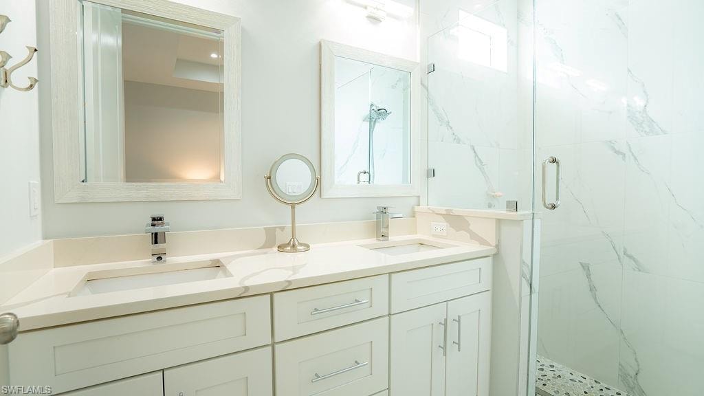 Double vanity with light-toned countertops and undermount sinks