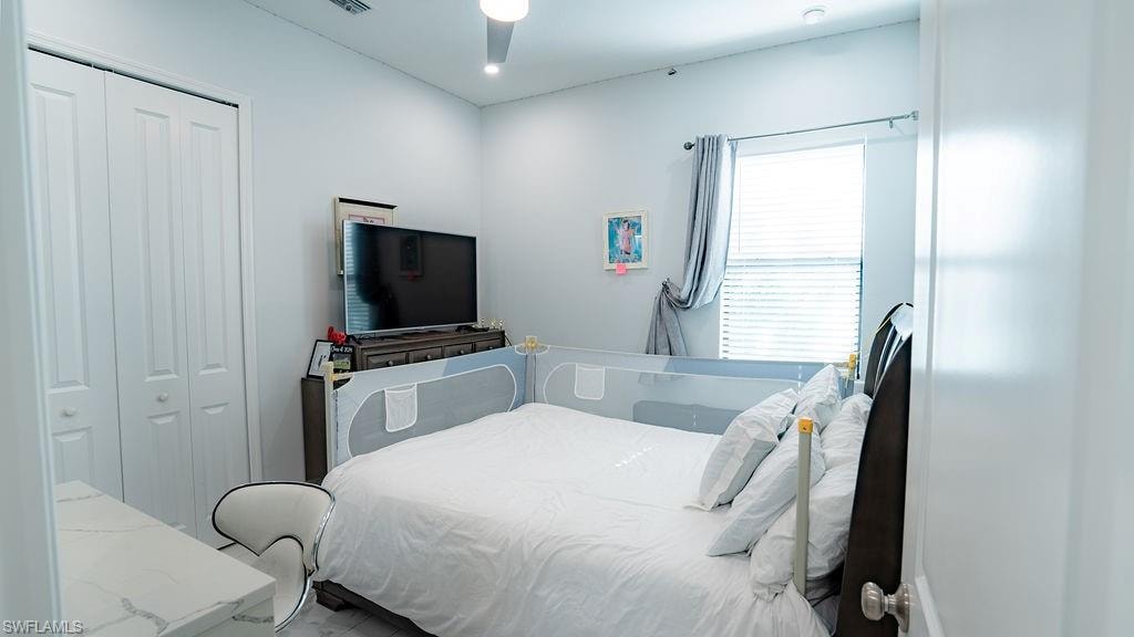 Bedroom featuring a window with blinds, bi-fold closet doors, recessed lighting, and a ceiling fan