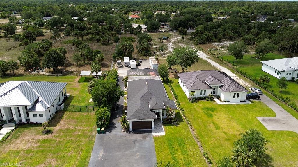 Aerial perspective showcasing a property with a dark shingle roof and an attached garage