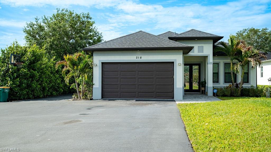 Contemporary single-story residence featuring a dark gray shingle roof and light gray stucco exterior