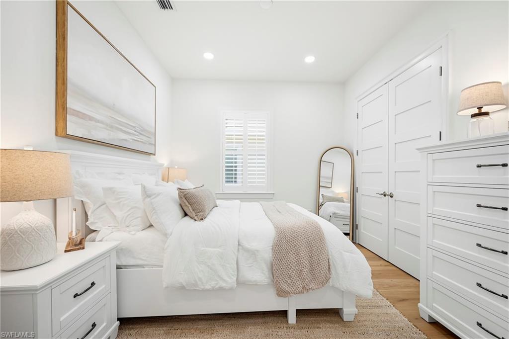 Bedroom featuring wood-finish flooring, recessed lighting, and a window with plantation shutters