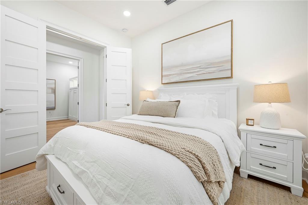 Bedroom featuring hardwood-style flooring, recessed lighting, and a white paneled door