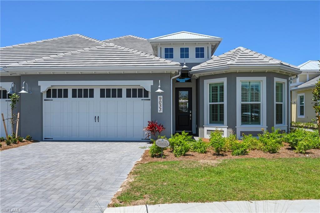 Modern exterior featuring a prominent bay window, a gray stucco facade, and a white paneled garage door