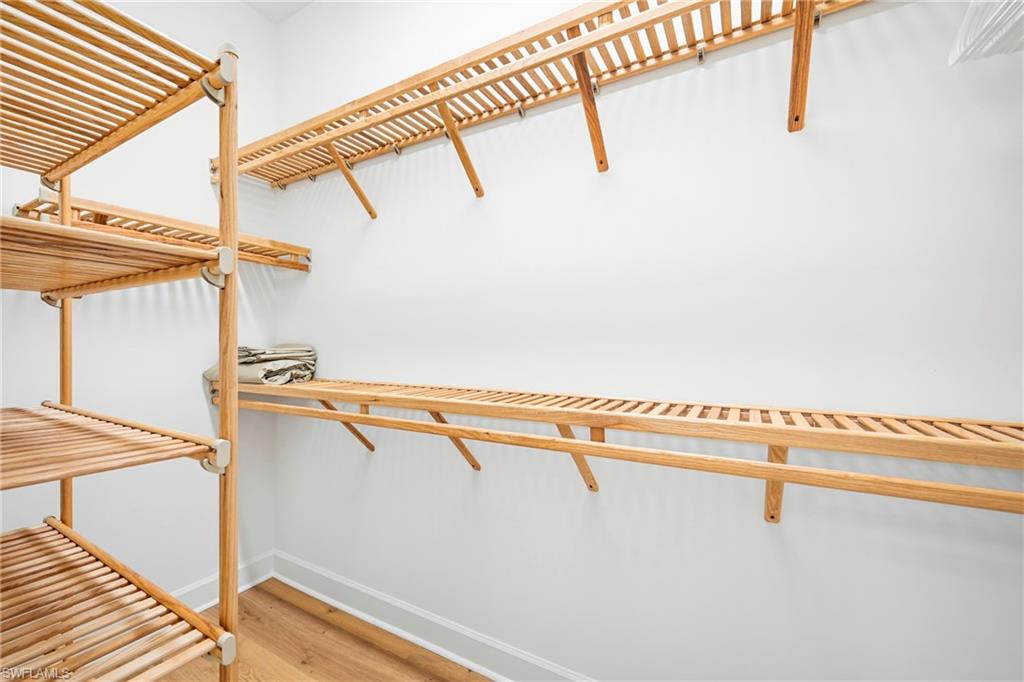 Custom built-in wood shelving system featuring slat-style shelves and a wood-finish flooring