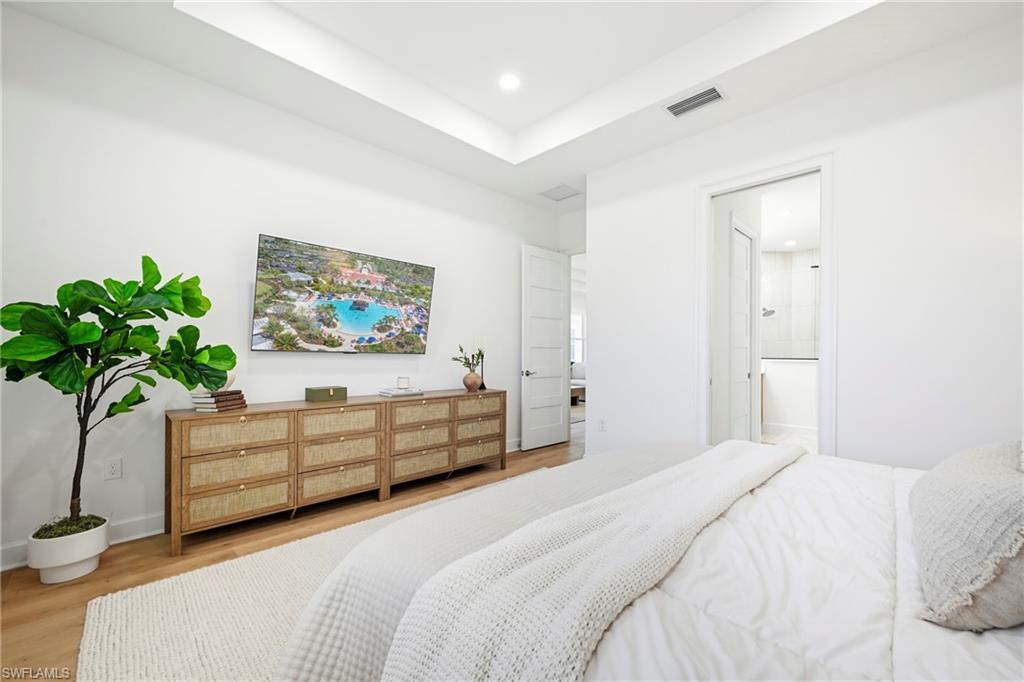 Bright room featuring light wood-finish flooring and recessed lighting