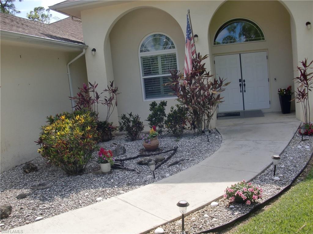 French door entry bordered by plants