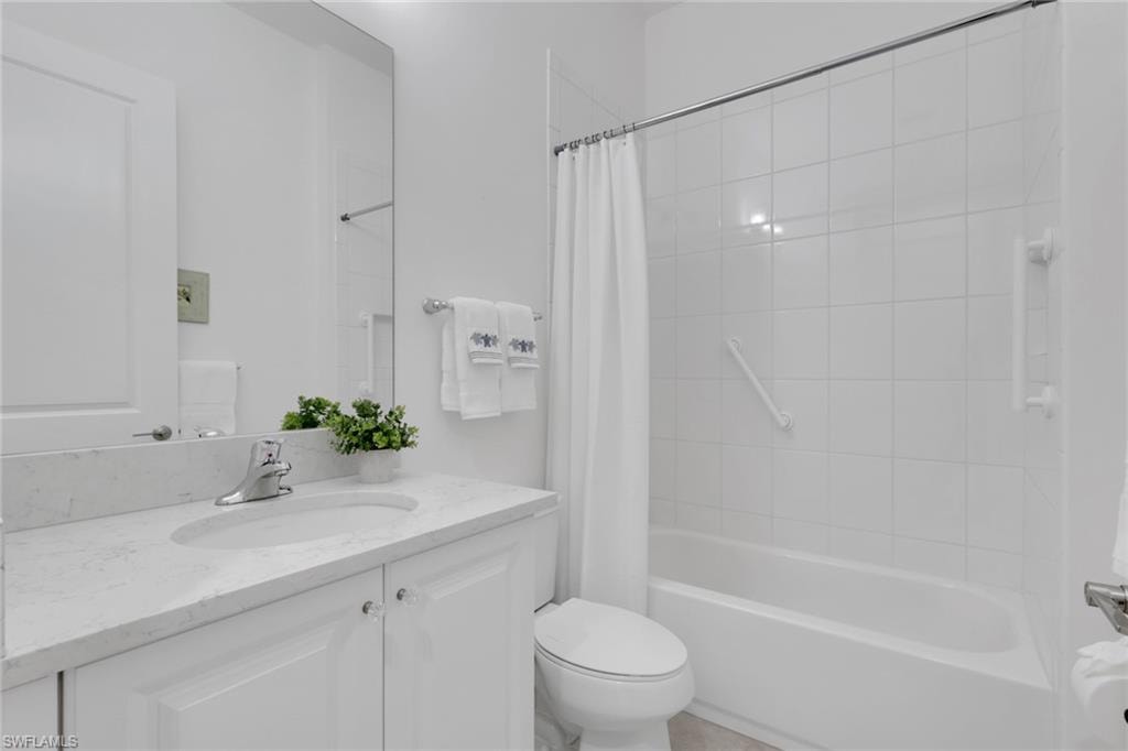 Modern bathroom featuring a single vanity with a light-colored countertop, an integrated sink, and white cabinetry