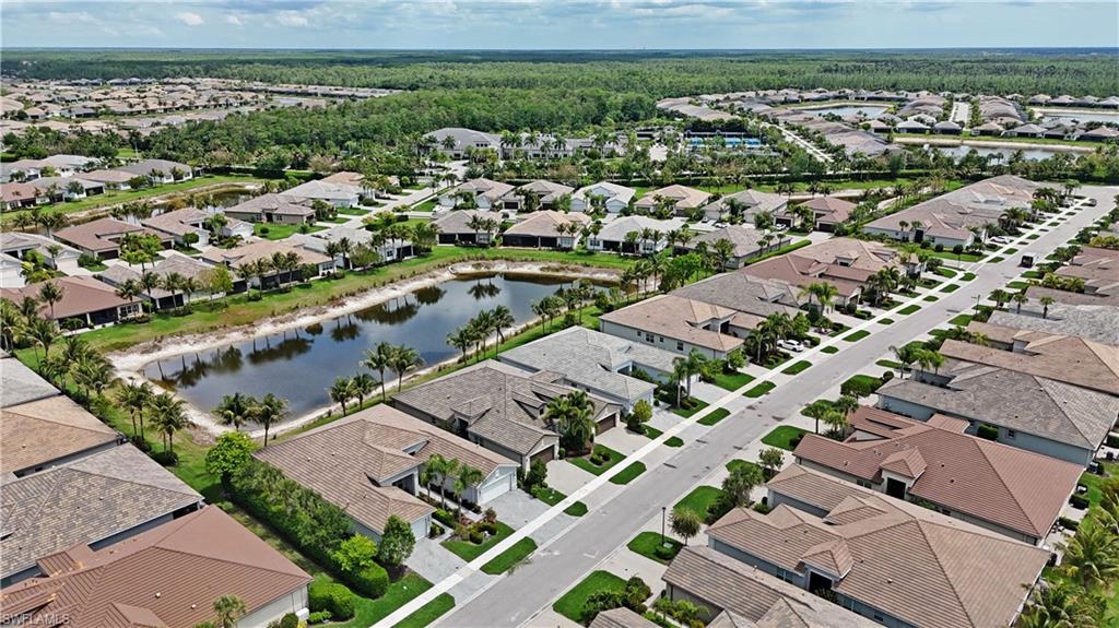Aerial perspective showcasing a residential community with numerous single-story homes featuring tile roofs and landscaped yards