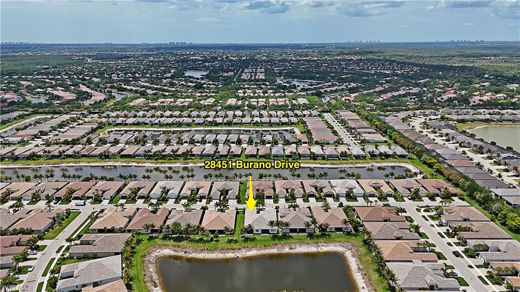 Aerial perspective showcasing a residential community with numerous properties featuring tile roofs and paved driveways