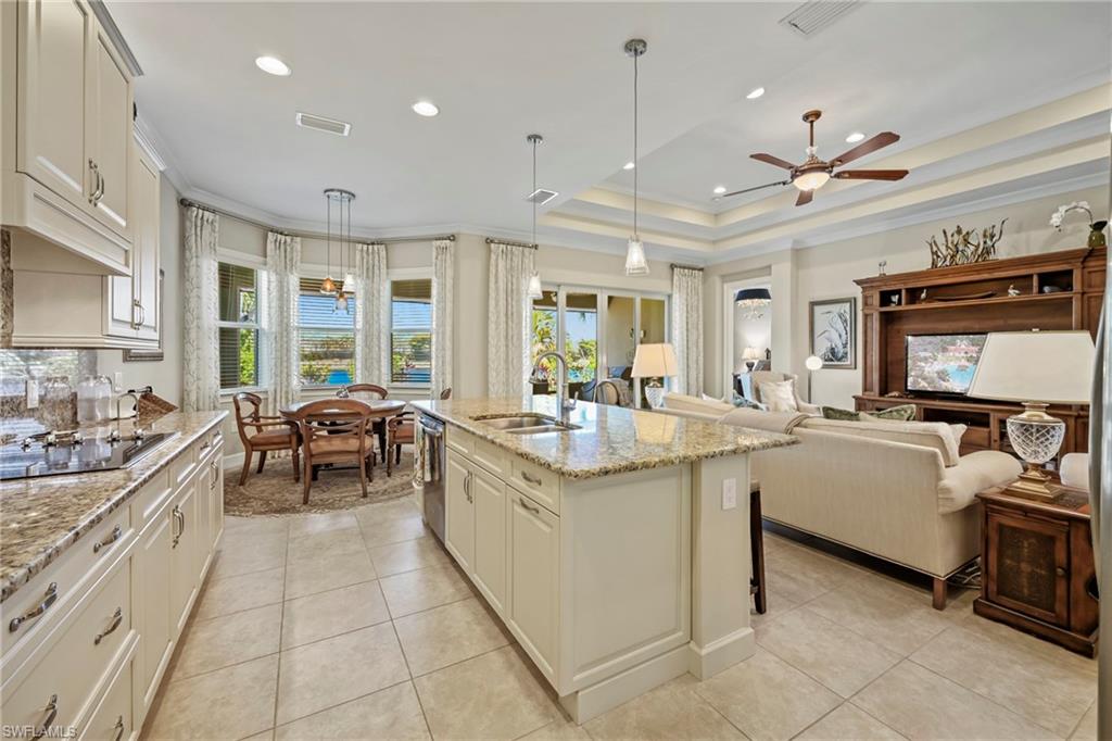 Kitchen and living area featuring a central island, recessed lighting, and tile flooring