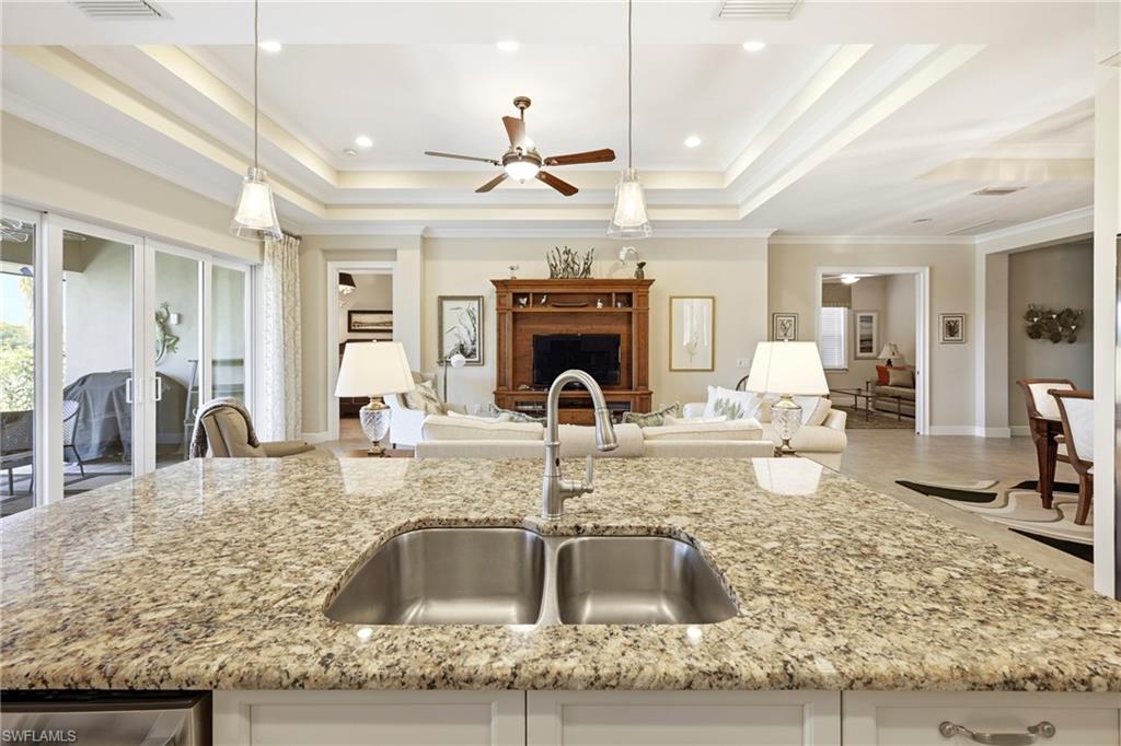 Spacious kitchen island featuring a double stainless steel sink and a gooseneck faucet