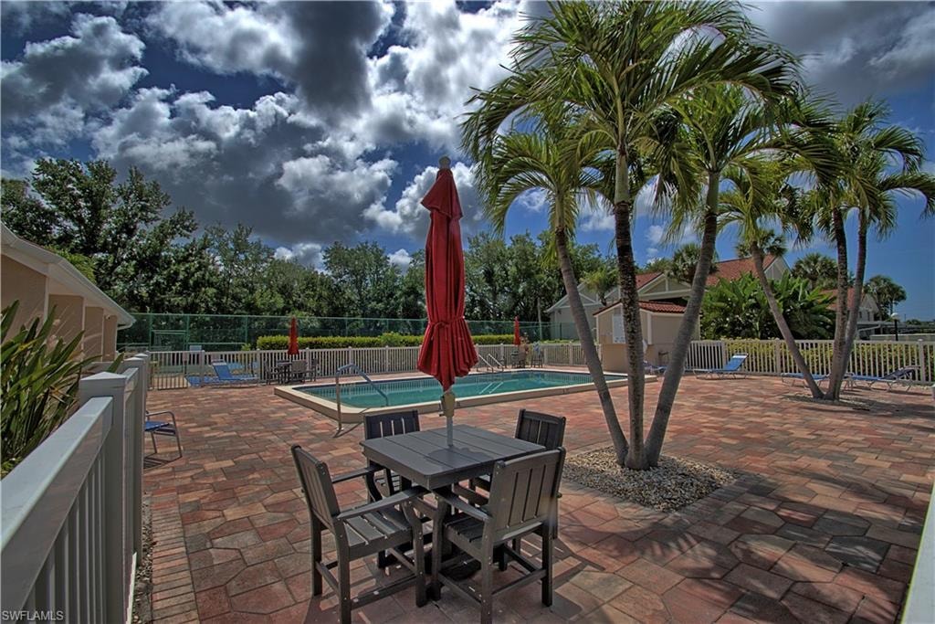 Expansive brick paver patio surrounding an in-ground swimming pool