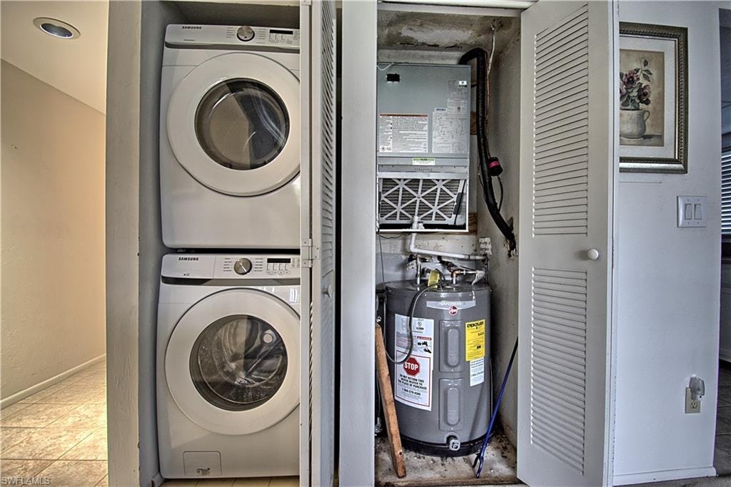 Dedicated laundry closet with stacked washer and dryer, adjacent to an HVAC system and water heater within a separate utility closet