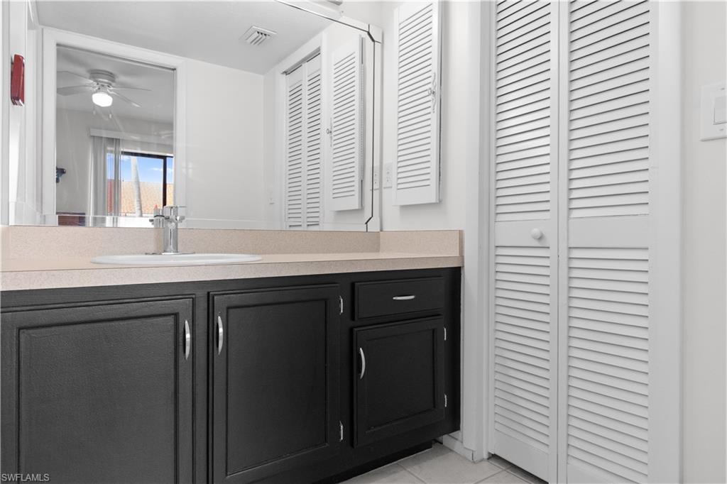 Bathroom vanity featuring black cabinetry and light-toned countertop.