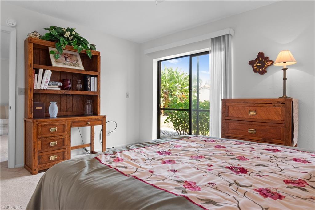 Bedroom featuring carpeted flooring, and a large sliding glass door.