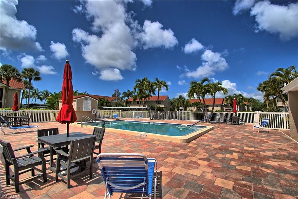 In-ground swimming pool with white perimeter fencing