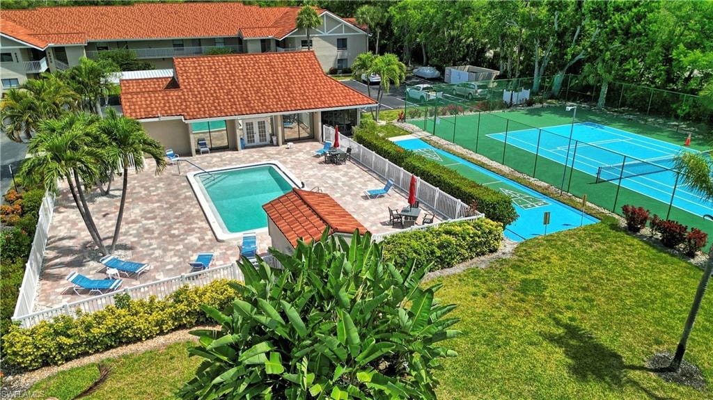 Community pool area featuring a paver patio,  and adjacent tennis and shuffleboard court