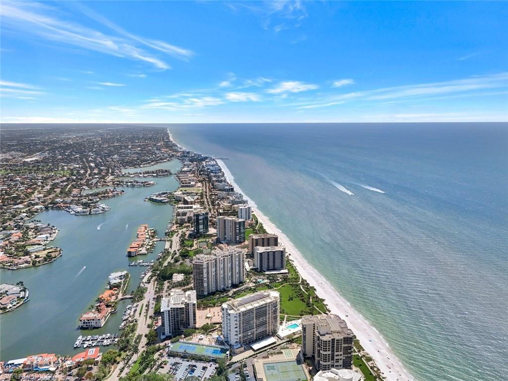 Birds eye view of property featuring a water view, a city view, and a beach view