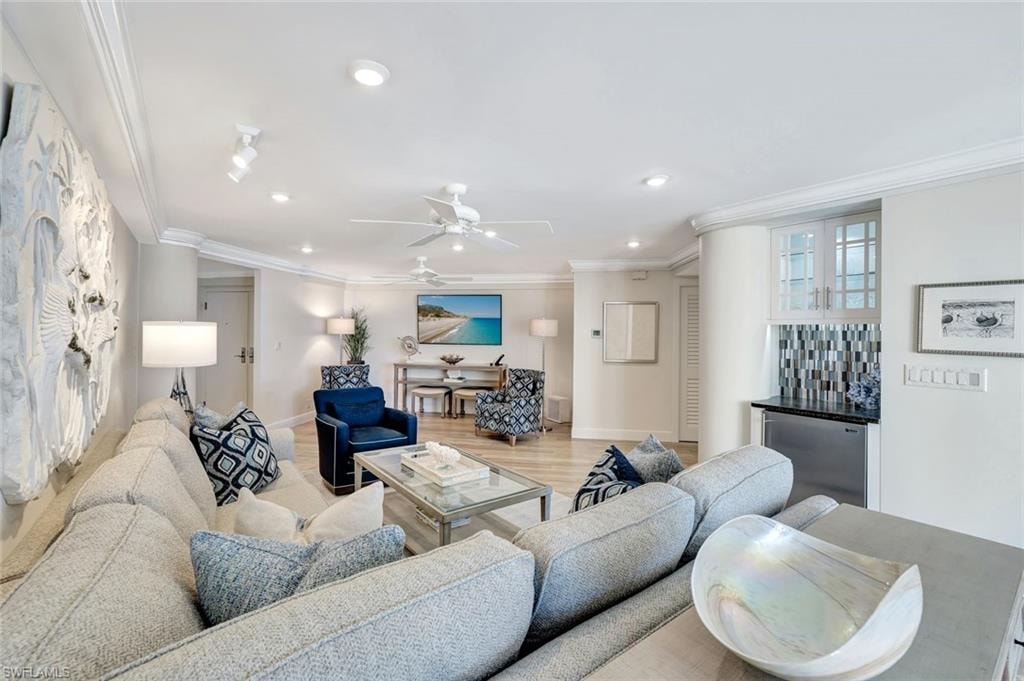 Living area with baseboards, a dry bar, ornamental molding, and recessed lighting