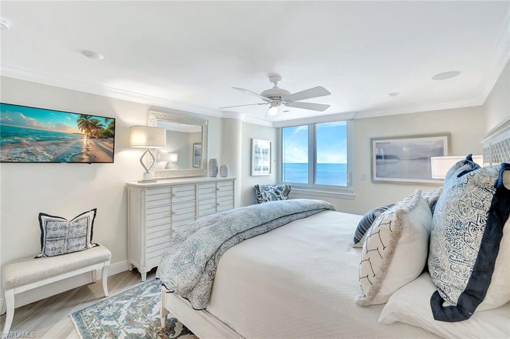 Bedroom featuring crown molding, baseboards, a ceiling fan, and light wood finished floors