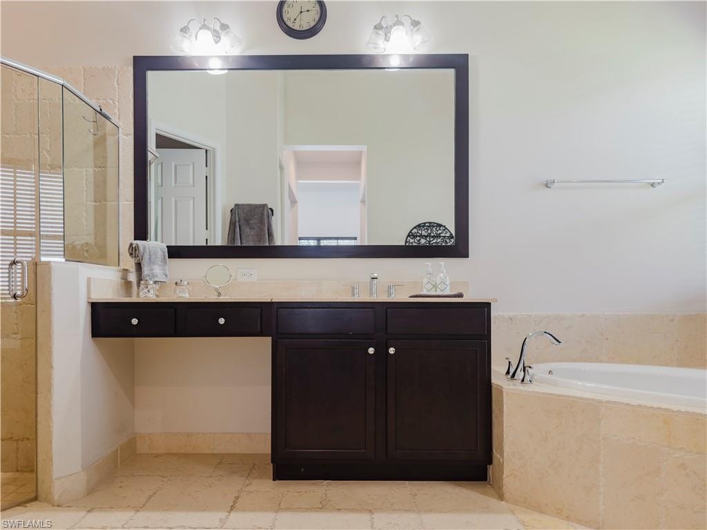Full bathroom with a stall shower, vanity, and a garden tub