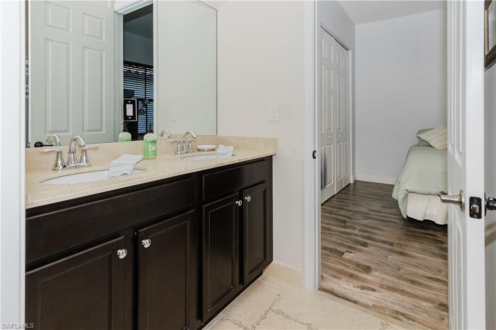 Ensuite bathroom featuring double vanity and wood finished floors