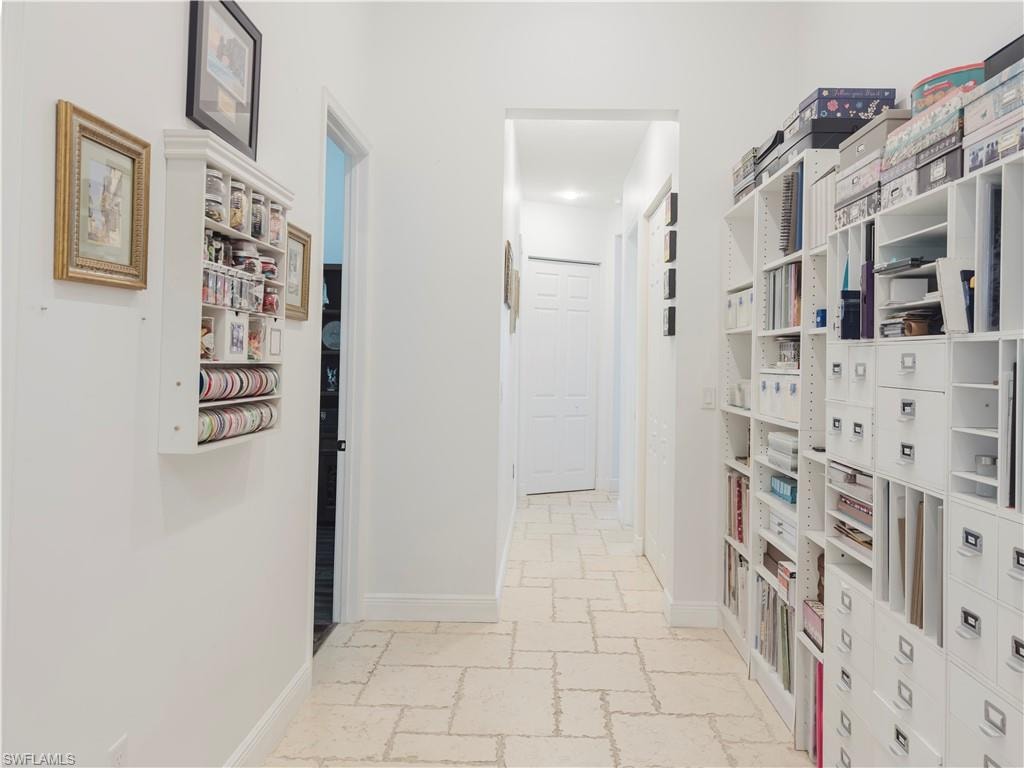 Corridor with stone tile floors and baseboards