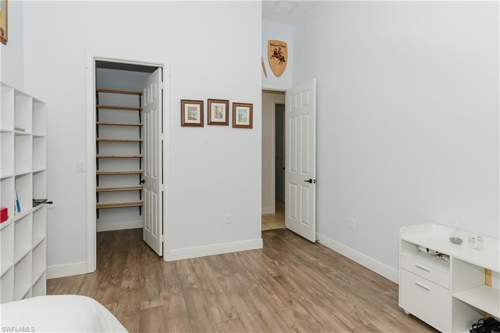 Bedroom featuring light wood-type flooring and a spacious closet