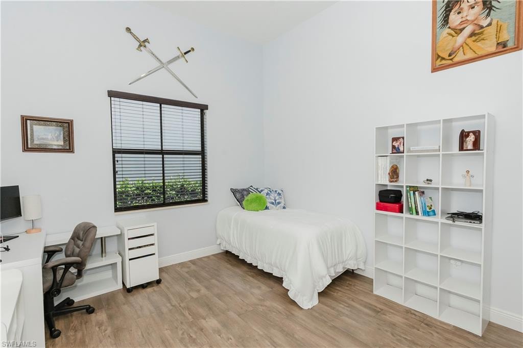 Bedroom featuring wood finished floors and an office area