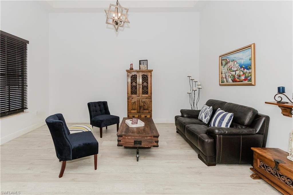 Living room featuring light wood-style flooring and a chandelier