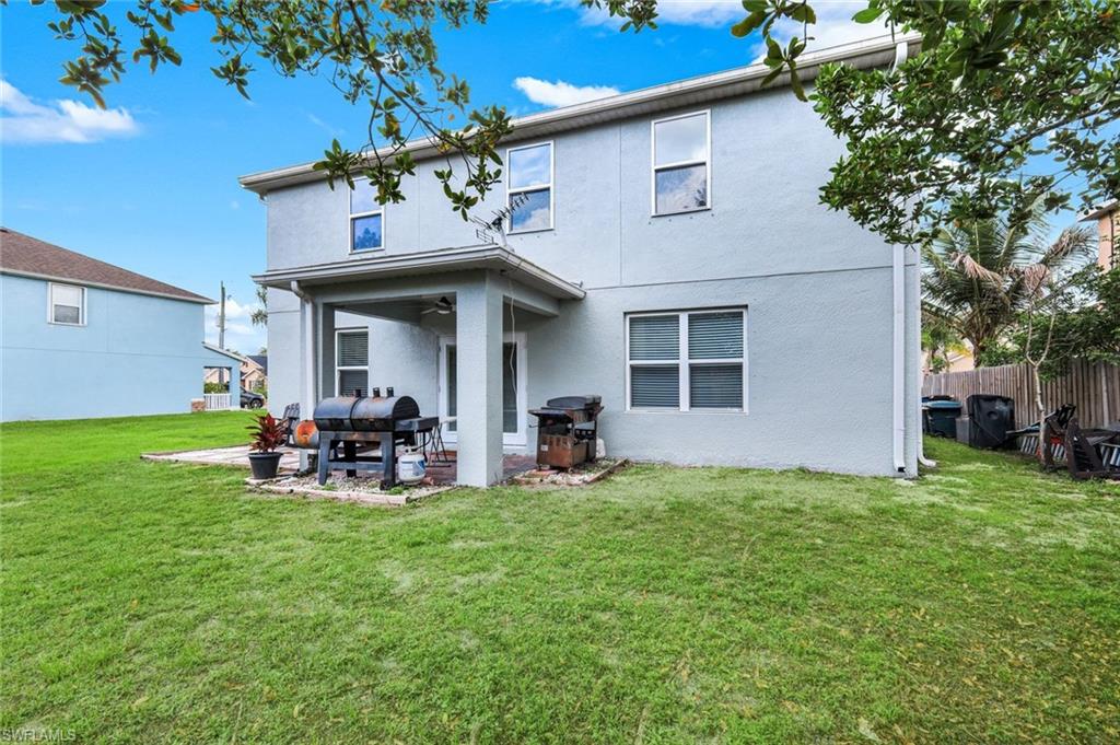 Expansive backyard featuring a manicured lawn, a covered patio, and a privacy fence