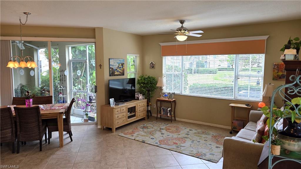Open-concept living space featuring neutral tone walls, tile flooring, and a ceiling fan with integrated lighting