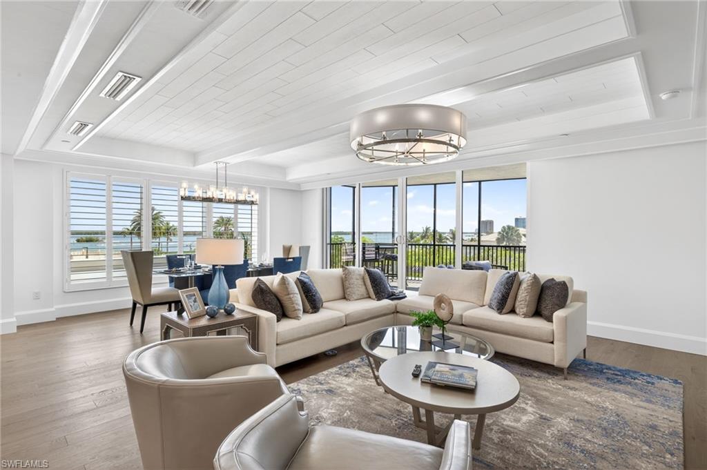 Coastal contemporary vibe throughout the living room and dining room space. The wall of floor to ceiling windows and glass slidiers sheds lots of natural light