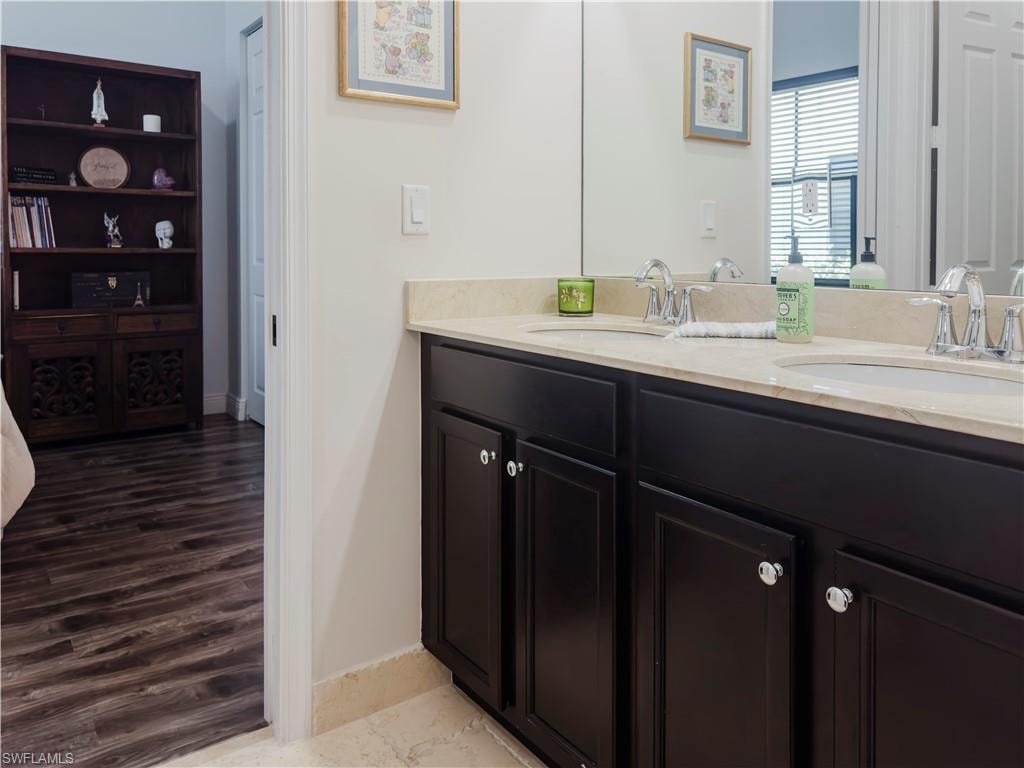 Bathroom with double vanity and baseboards