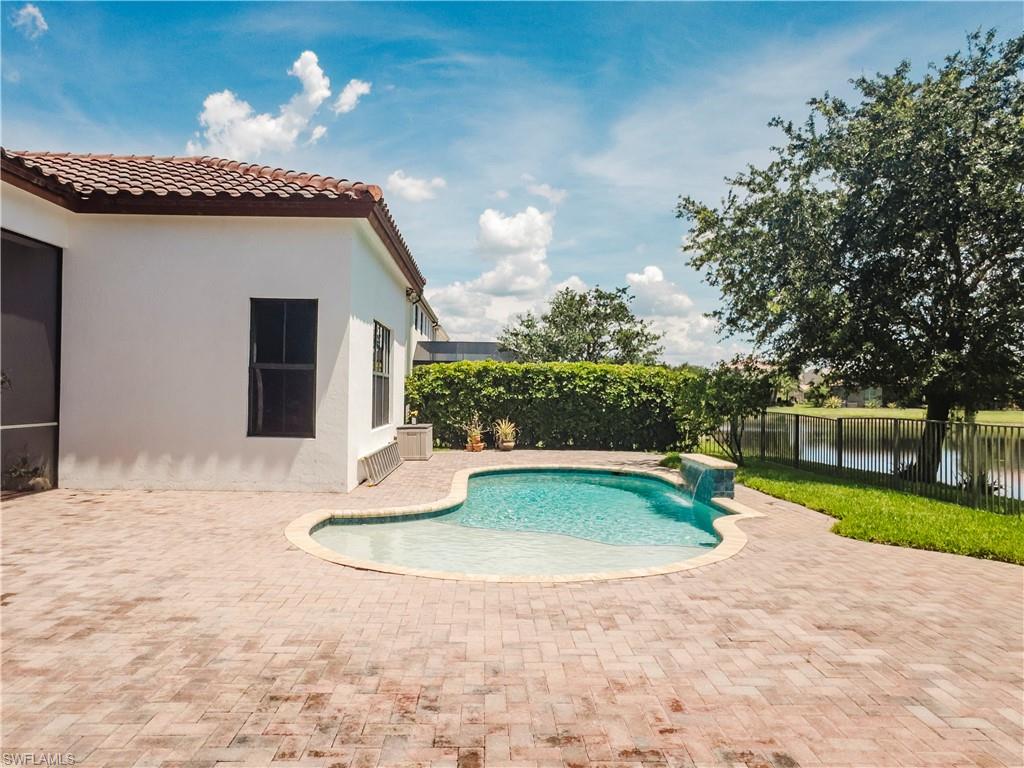 View of swimming pool featuring a fenced backyard, a patio, and a water view