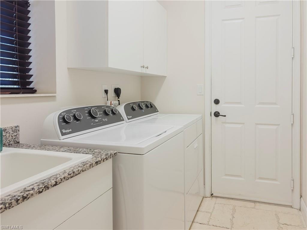 Washroom featuring cabinet space and separate washer and dryer