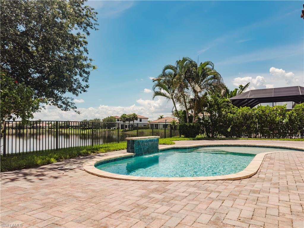 View of swimming pool with a fenced backyard, a patio area, and a water view