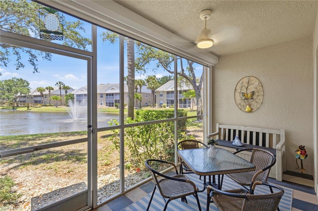 Screened lanai featuring a ceiling fan, textured walls, and direct access to outdoor space