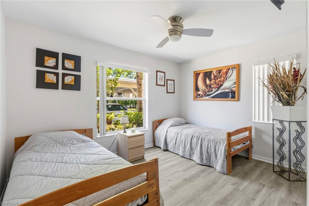 Bright room featuring a window with exterior views, wood-finish flooring, and a ceiling fan
