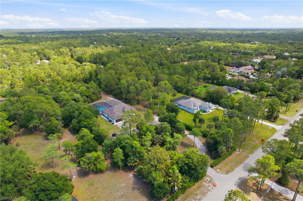 Aerial view showcasing multiple properties surrounded by extensive natural foliage