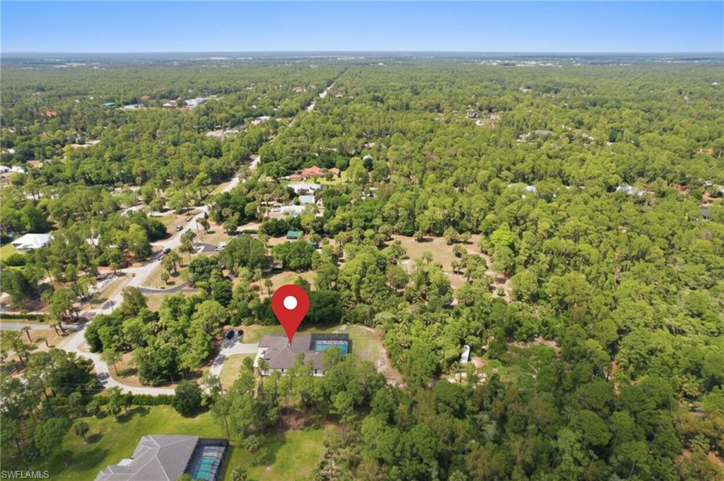 Aerial view of a residential property surrounded by mature trees