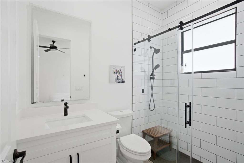 Modern bathroom featuring a white vanity with integrated sink, black faucet, and a large wall-mounted mirror