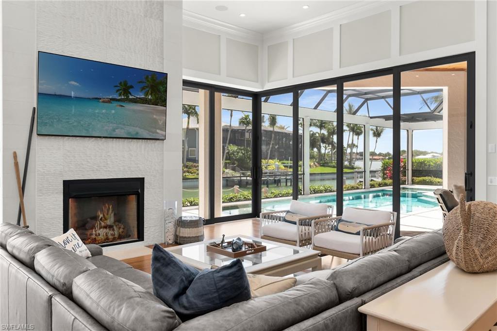 Living room featuring a tiled fireplace, wood-finish flooring, and expansive sliding glass doors