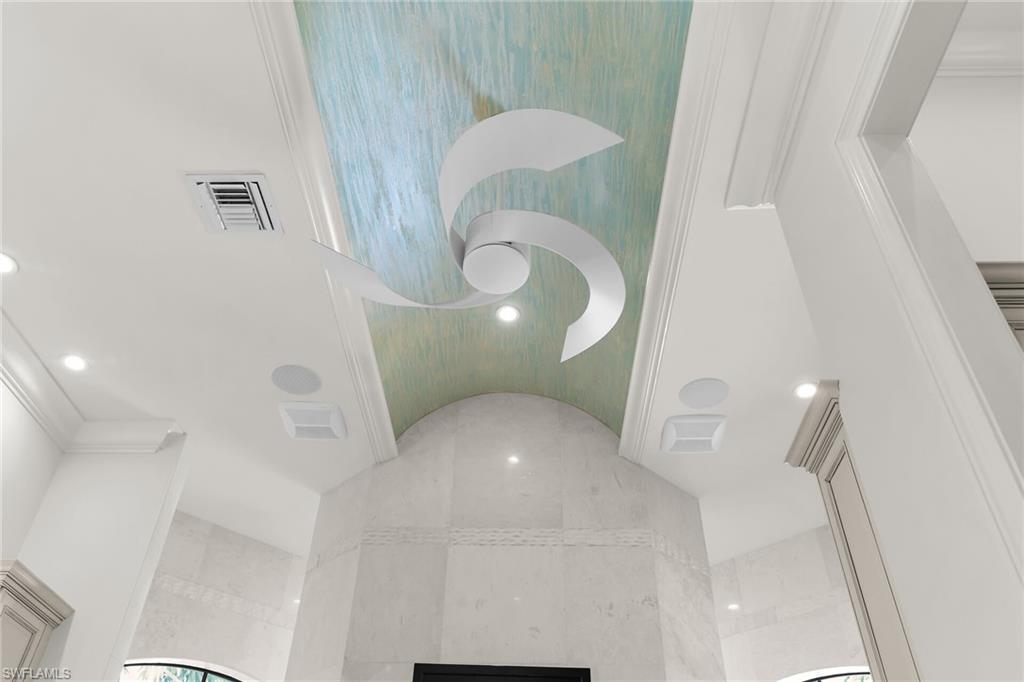 Sculptural ceiling fan set against an arched, textured ceiling panel