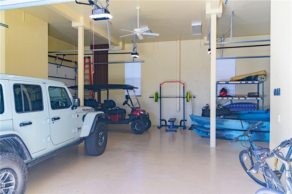 4+ Car Spacious garage featuring 3overhead garage doors, a ceiling fan, recessed lighting, and support columns